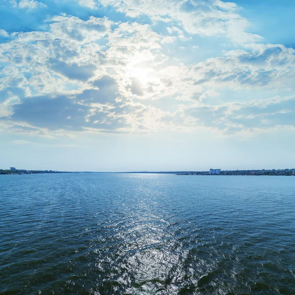 Blauer Fluß mit Reflexionen der Sonne in den Wolken — Stockfoto