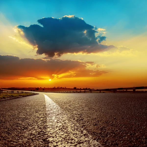 Pôr do sol dramática sobre asfalto estrada closeup — Fotografia de Stock