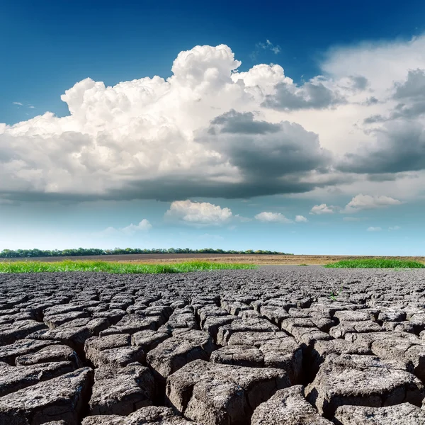 Primo piano di terra di siccità e nubi basse in cielo blu — Foto Stock