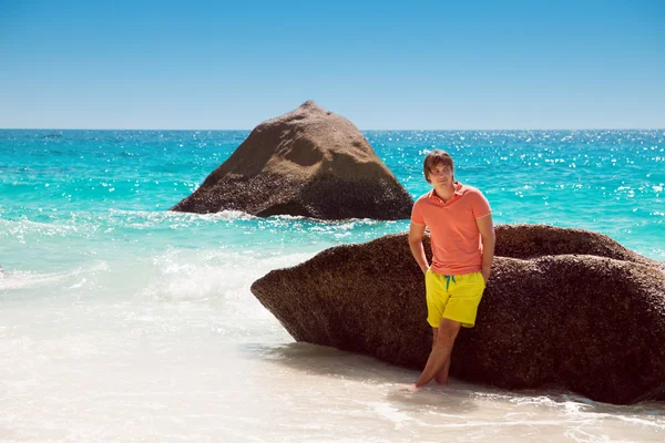 Knappe jonge man op een tropisch strand, ontspannen op zomervakantie — Stockfoto