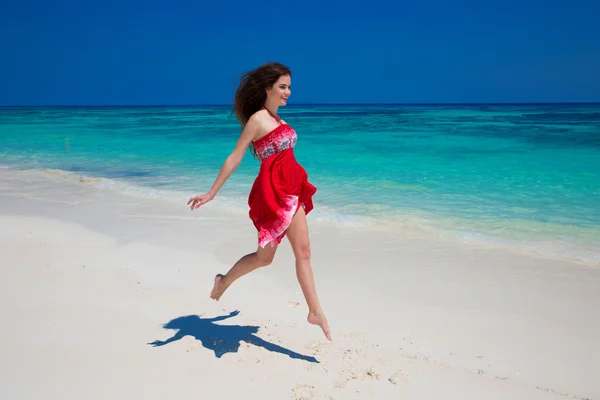 Menina sorridente bonita correndo na praia exótica com areia branca a — Fotografia de Stock