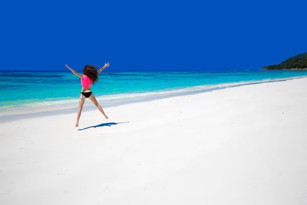 Disfrutando de la vida. Mujer feliz saltando en el mar exótico. Ajuste morena g —  Fotos de Stock