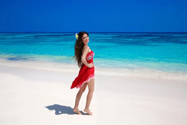 Vackra leende kvinna i röd klänning njuter på exotiska havet, tropisk strand. sommaren utomhus porträtt. Attraktiv tjej modell. Wellness. Livsstil. Bliss frihet koncept. Resor. — Stockfoto