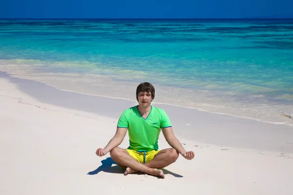 Young man in yoga lotus pose on exotic beach, tropical island ba — Stock Photo, Image