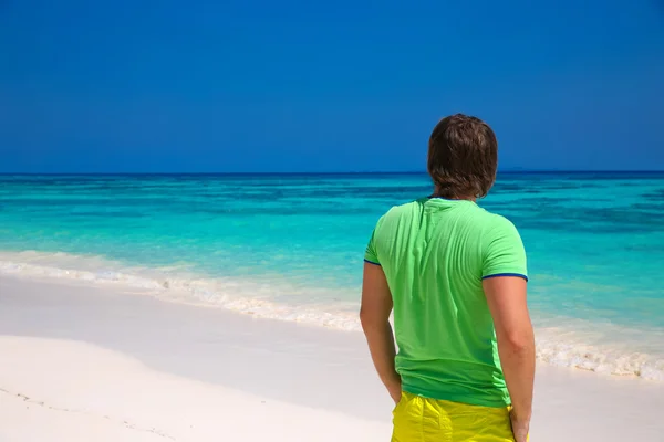 Vue arrière de l'homme heureux jouissant d'une bonne vie sur la plage exotique, gars l — Photo