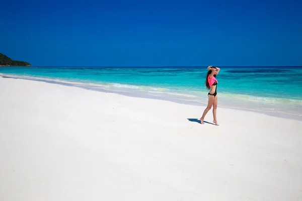 人生を楽しんでいます。健康な女性は、エキゾチックな海の上を歩きます。フィットのブルネット — ストック写真