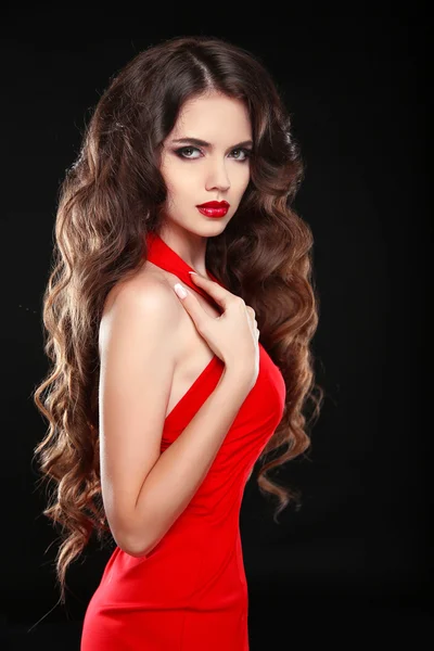 Vacker tjej med långt vågigt hår i röd klänning. Brunett med c — Stockfoto