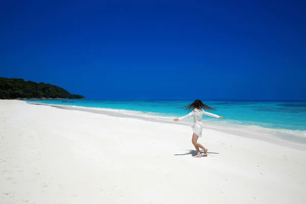 Наслаждайтесь. Счастливая женщина с распростертыми объятиями на пляже, экзотика — стоковое фото
