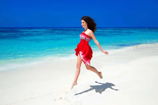 Свободная девушка бегает по экзотическому пляжу с белым песком и — стоковое фото