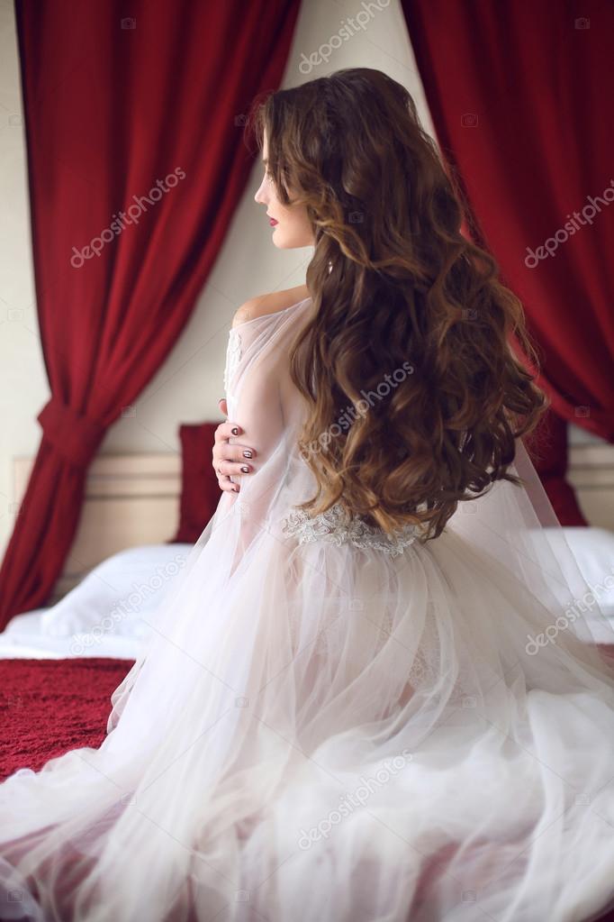 Amazing luxury elegant woman in stylish golden party dress posing before  white feathers wall. Fashion beautiful sensual female with makeup, curly  hair style in long prom gown. Photos | Adobe Stock