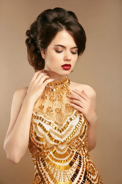 Senhora elegante em vestido dourado isolado em fundo bege. Makeu. — Fotografia de Stock