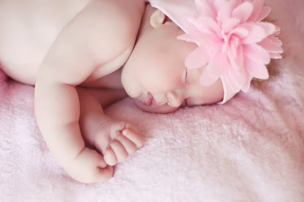 Close-up beautiful sleeping baby girl. Newborn baby girl with fl — Stock Photo, Image