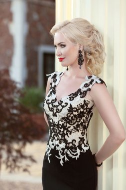 Zarif elbiseli güzel sarışın bayan. Saç modeli. Kırmızı dudaklar makeu