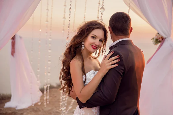 Hochzeitsporträt der schönen lächelnden Braut und des Bräutigams unter Hochzeitskleid — Stockfoto