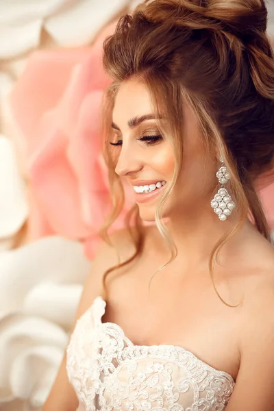 メイクやファッション結婚式の髪型と魅力的な若い花嫁 バラの壁の花の上に若い豪華な女性のクローズアップ肖像画 スタジオショット — ストック写真