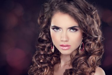 güzel esmer kadın. uzun dalgalı saçlar. moda küpe. Profe