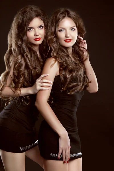 Beautiful two Young women with long healthy wavy hair styling an — Stock Photo, Image