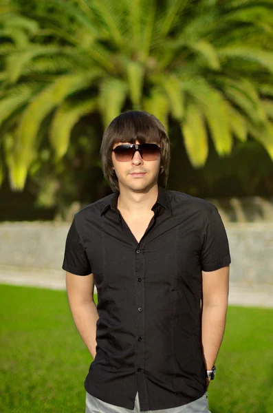 Jeune homme beau portrait en plein air. Homme branché dans les lunettes de soleil — Photo