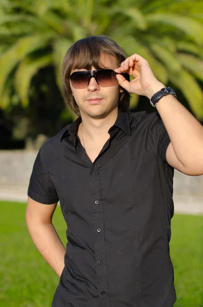 Jeune homme beau portrait en plein air. Homme branché dans les lunettes de soleil — Photo