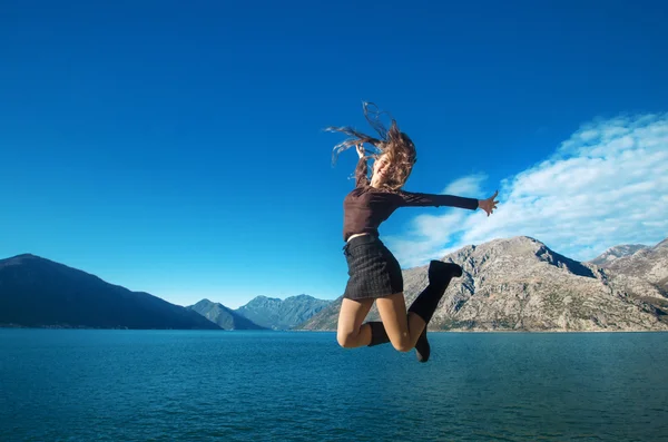 Menina de salto bonita apreciando a natureza com seus braços abertos sobre — Fotografia de Stock