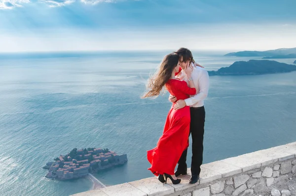 Romántica pareja abrazando junto al mar azul en frente de Sveti Stef — Foto de Stock