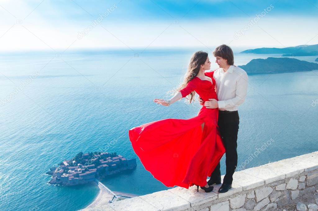 Romantic young couple in love. Fashion girl model in blowing red