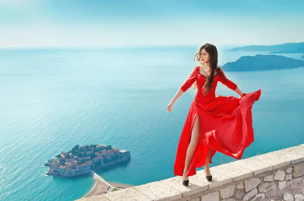 Hermosa chica en soplado vestido rojo Volando. Moda mod magnífico — Foto de Stock