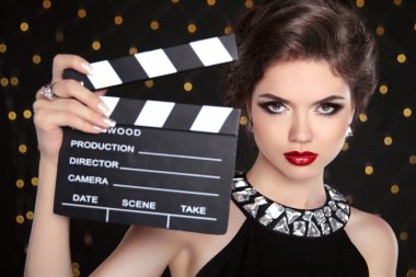 Beautiful brunette woman model holding film clap board cinema. F clipart
