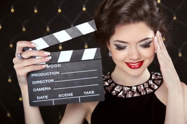 Fashion elegant woman posing with sexy red lips holding cinema c