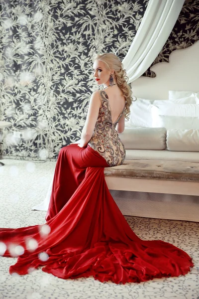 Elegantní blondýnka modelka se v luxusní červené šaty s lon — Stock fotografie