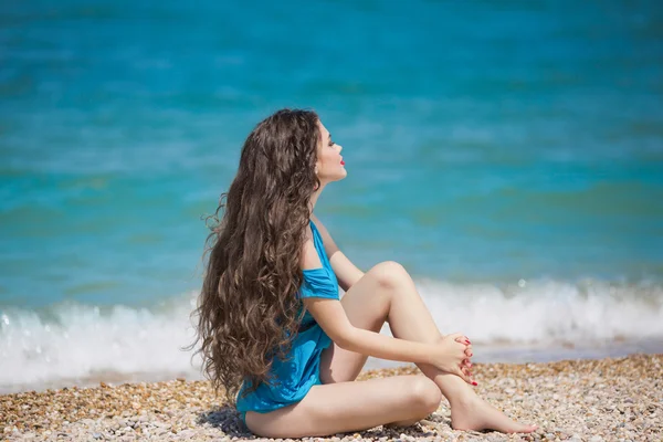 Menina morena nova desfrutando e tomando sol na praia com lo — Fotografia de Stock