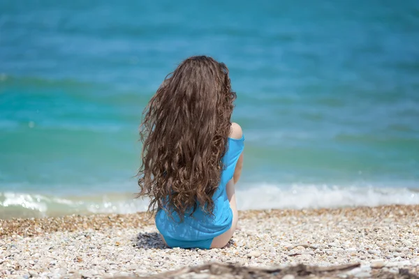 Uzun saçlı. Genç çekici kadın rahatlayın plajda mavi wat tarafından — Stok fotoğraf