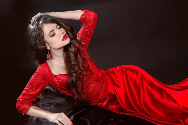 Woman in red lying in the dark. Fashion tempting girl model in s — Stock Photo, Image