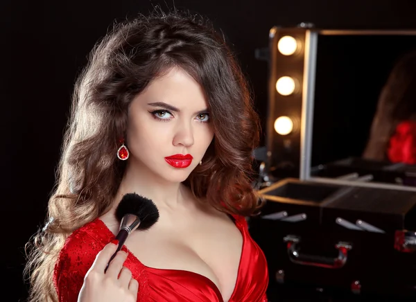 Styliste beauté. Belle femme en rouge avec brosse de maquillage en fro — Photo