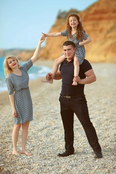 Glad familj porträtt på stranden. far och mor gå wi — Stockfoto