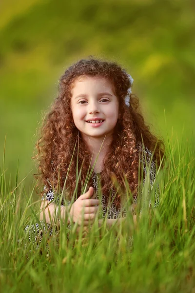 Retrato de niña sonriente divertida con el pelo rizado en g verde — Foto de Stock