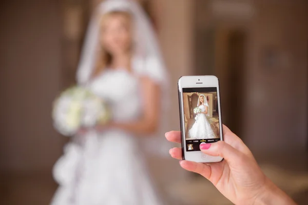 Fotka krásná nevěsta ujímá chytrý mobilní telefon. Svatba d — Stock fotografie