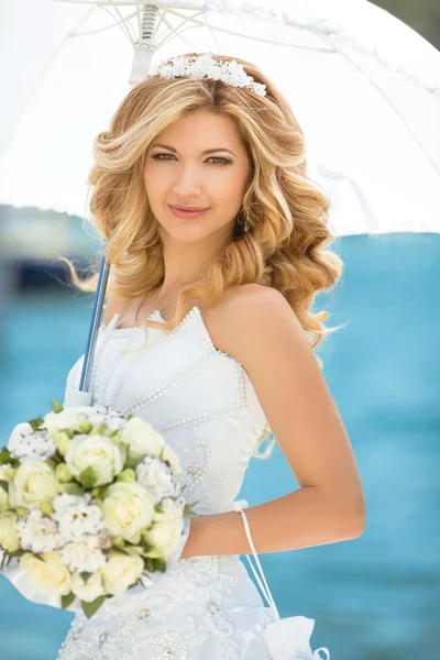 Mooi lachende bruid meisje in bruiloft jurk met witte umbrell — Stockfoto