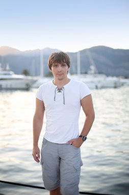 Günbatımı ve lüks yat arka plan t önünde yakışıklı adam