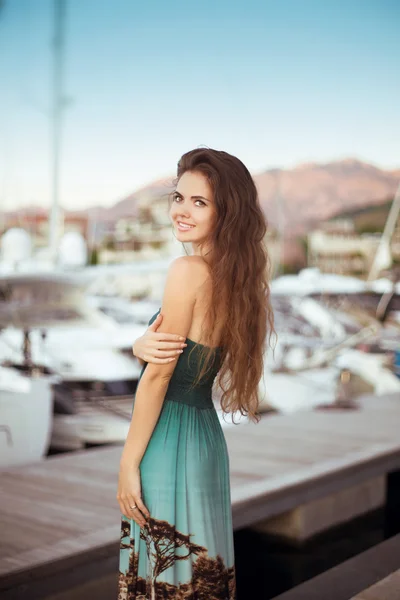 Красива усміхнена дівчина-підліток з довгим волоссям позує на яхтах — стокове фото