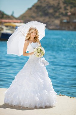 Gelinlik beyaz umbrell ile gülümseyen güzel gelini kızı