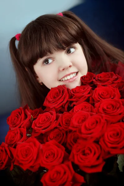 Kırmızı gül buketi çiçek taşıyan küçük kız gülümseyerek mutlu — Stok fotoğraf