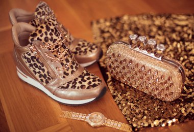 Moda leopar spor ayakkabı Glamour altın kol saati ve cüzdanı ahşap arka plan üzerinde. Moda Bayan aksesuarları.