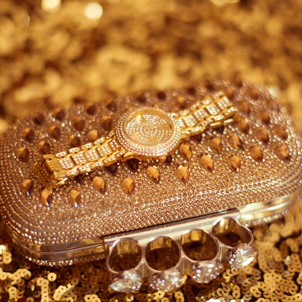 Luxus reiche goldene Armbanduhr und Geldbörse, auf goldenen Pailletten - spa — Stockfoto