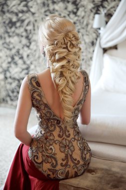 Elegant hairstyle. Beautiful blond woman in fashion red dress si