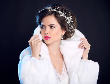 Fashion girl model in white fur coat, luxury jewelry, elegant ha