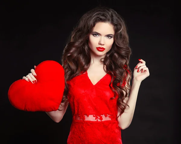 Schönes Mädchen mit langen welligen Haaren in rotem Kleid, das Valentin hält — Stockfoto