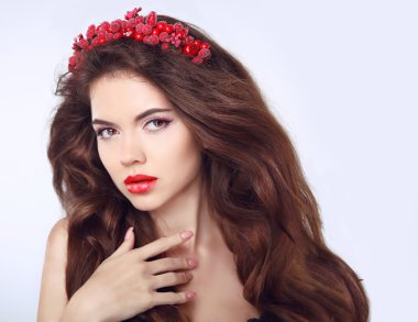 Beautiful girl model with chaplet on the head. Long brown wavy h