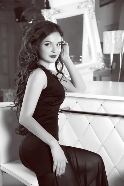 Schöne brünette sexy frau modell im schwarzen eleganten kleid sitti — Stockfoto