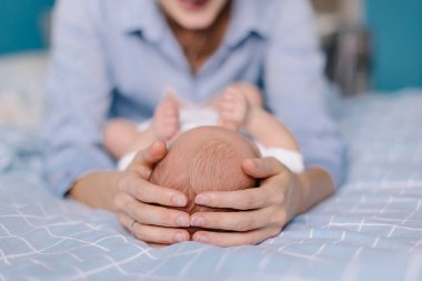 Anne, bebeğin kafasını ellerinin arasında tutuyor. Annelik anne sevgisidir. Yeni doğmuş şirin bir bebek. Hassasiyet koruma konsepti. - Çocuk uyuyor. Yaşam tarzı gerçek hayat. 